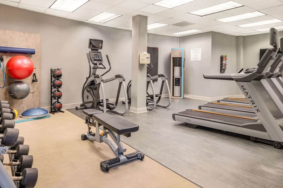 Well-equipped fitness center with treadmills, exercise bikes, free weights, and gym equipment