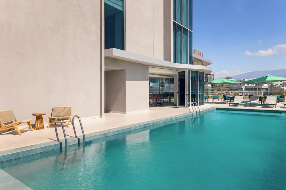 Modern pool beside contemporary home with turquoise water and minimalist deck