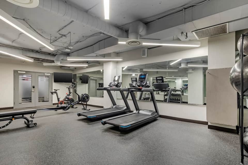 Fitness center with treadmills, exercise bikes, and gym equipment in well-lit space