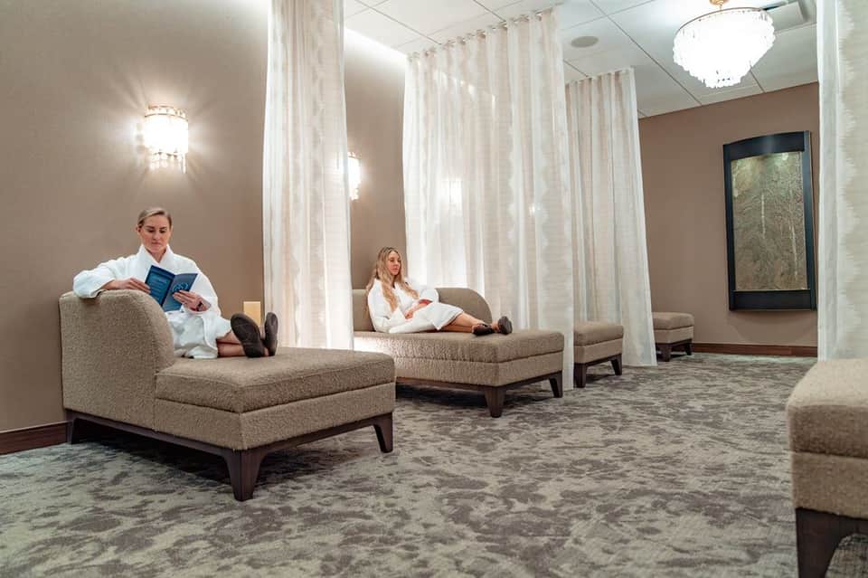 Spa relaxation area with comfortable lounge seating separated by sheer white curtains