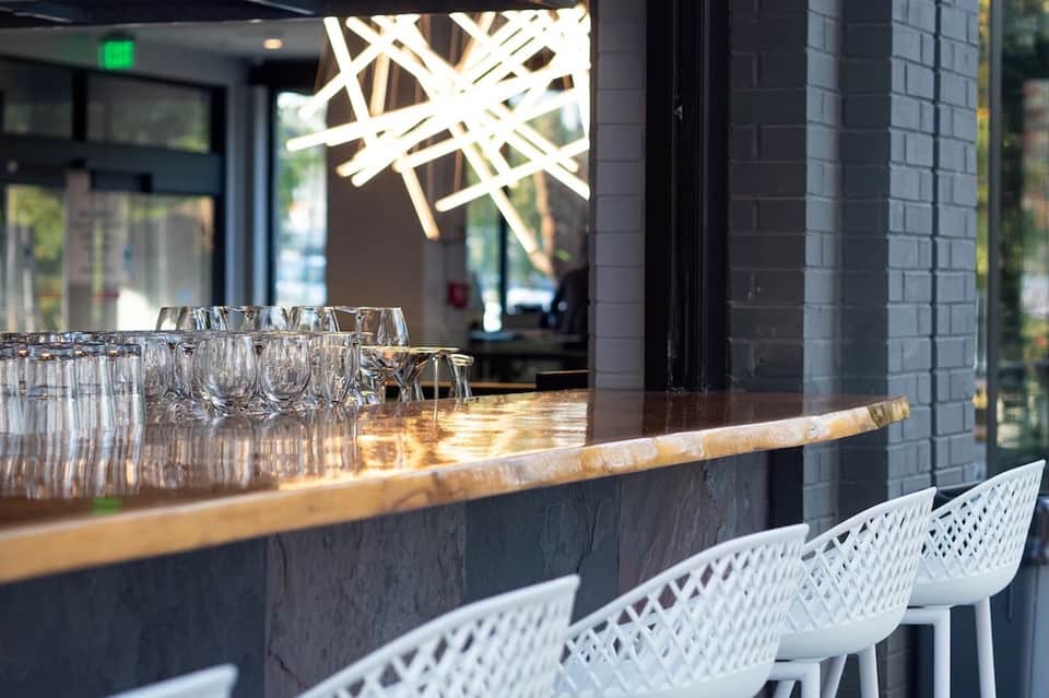 Modern bar counter with glasses and geometric ceiling light fixture