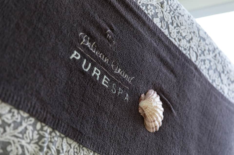 Close-up of hotel towel with seashell detail and pure spa branding