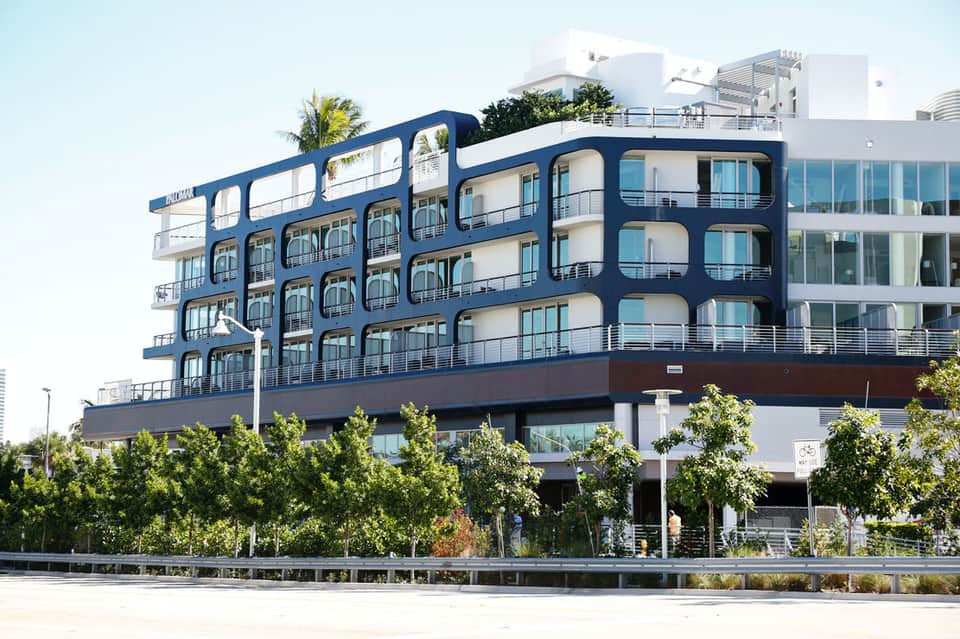 Modern multi-story residential building with distinctive blue curved facade and balconies