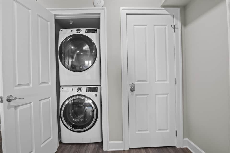 Stacked washer and dryer units in white laundry room closet