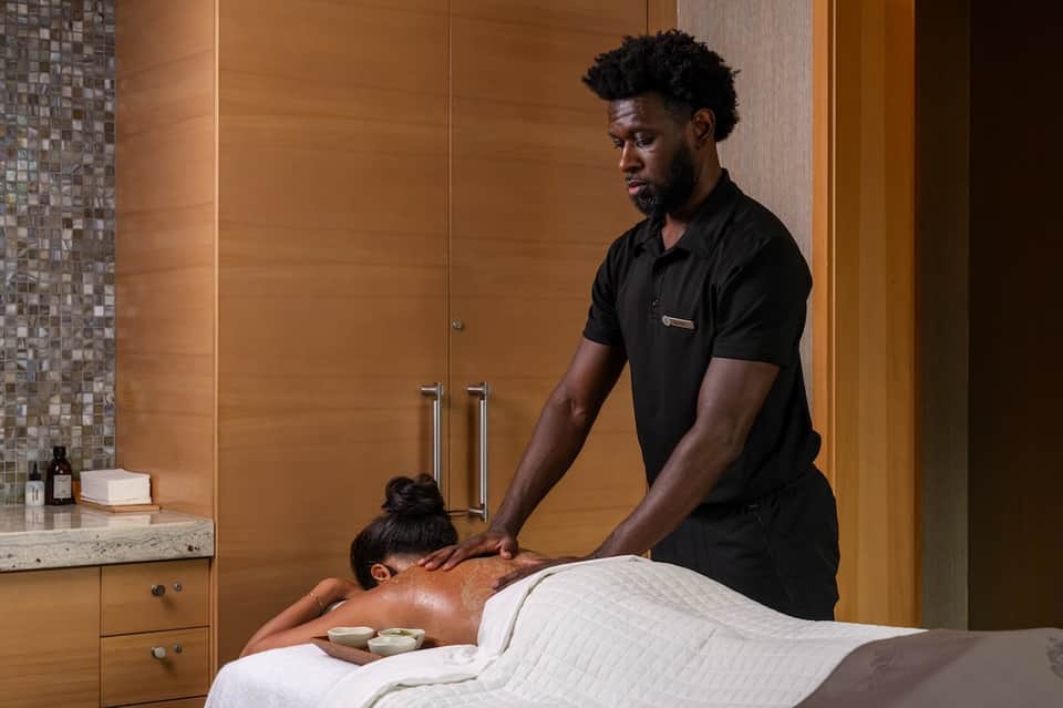 Spa therapist providing professional massage treatment to client in relaxation room