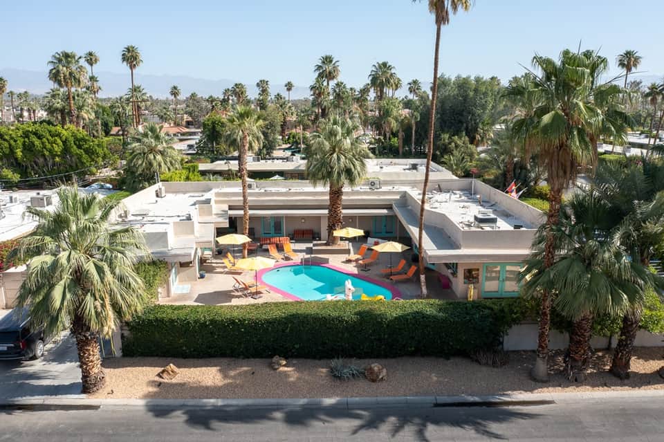 Colorful mid-century modern pool with geometric design, loungers, and desert landscape