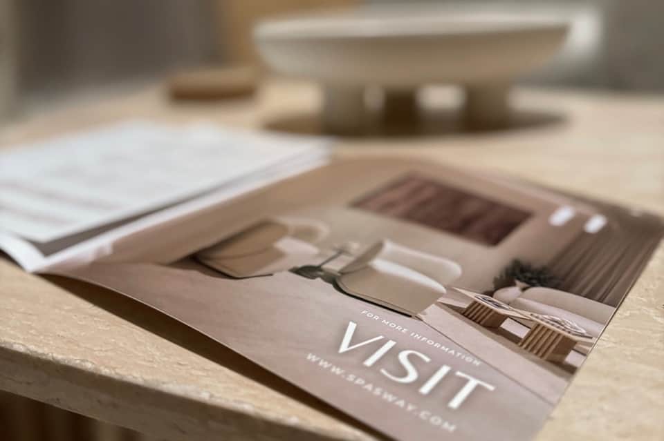 Close-up of spa brochure on marble surface with blurred spa imagery in background