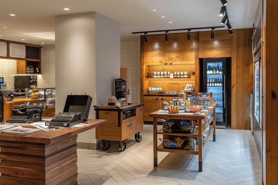 Modern hotel lobby coffee shop with wooden shelving and beverage counter