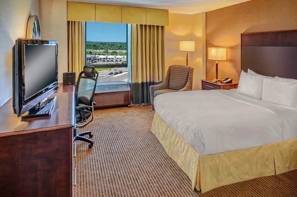 Hotel room with yellow bedding, city view from balcony, and modern furnishings