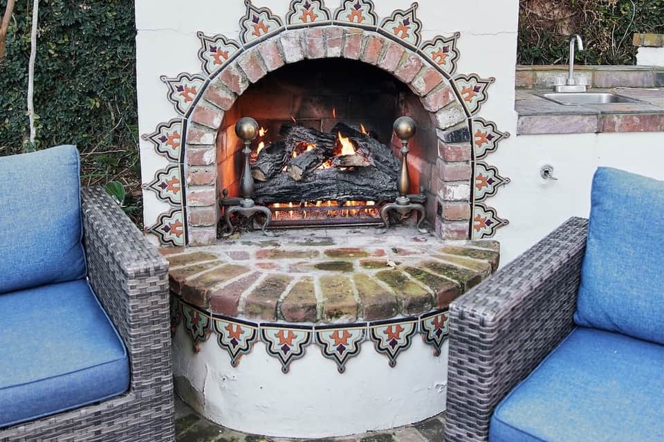 Ornate brick fireplace with decorative surround and blue lounge seating