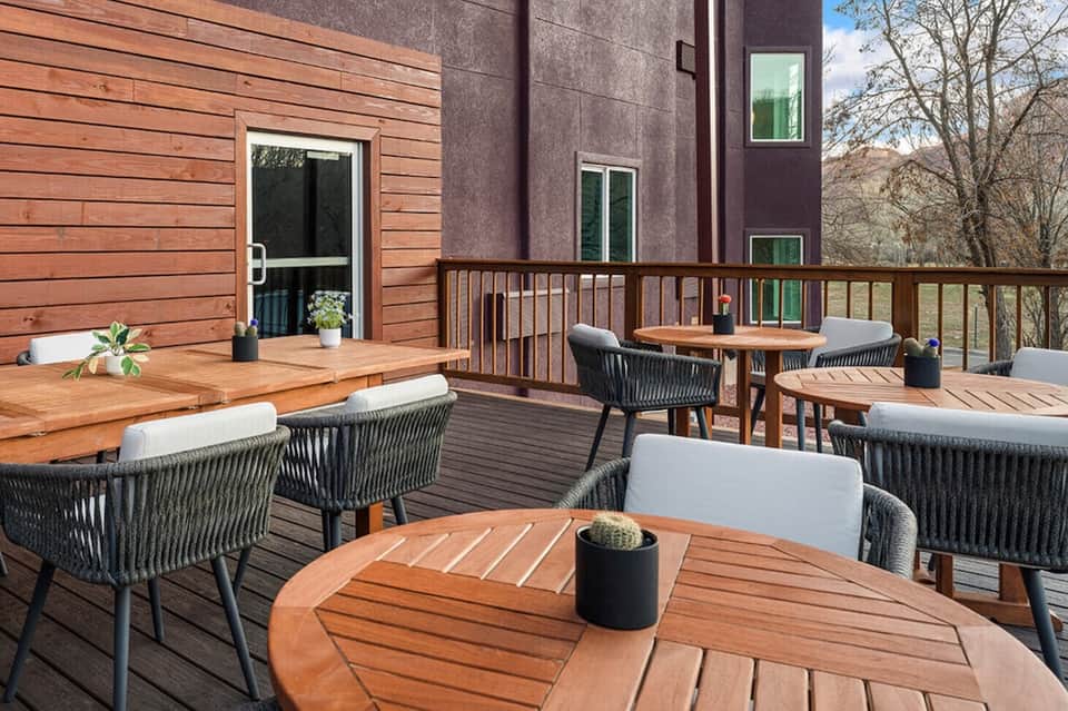 Modern wooden deck with contemporary outdoor furniture overlooking forested landscape