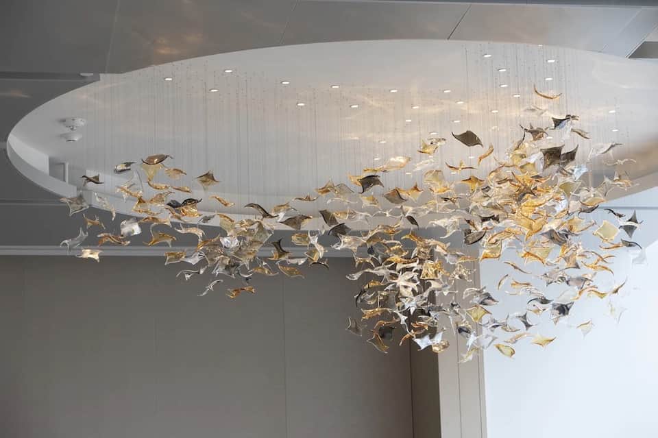 Dramatic chandelier with hundreds of gold and silver sculptural leaves in hotel lobby