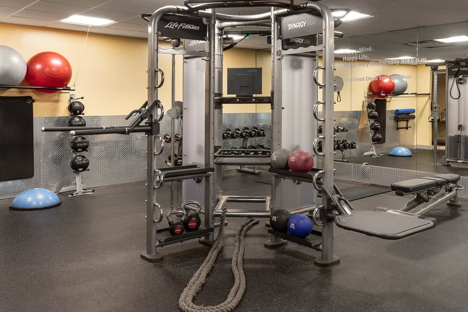 Fitness center with multi-functional exercise equipment, dumbbells, and stability balls