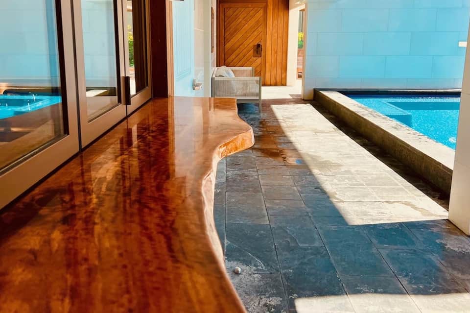Indoor swimming pool with polished concrete floors, large windows, and blue tile accents