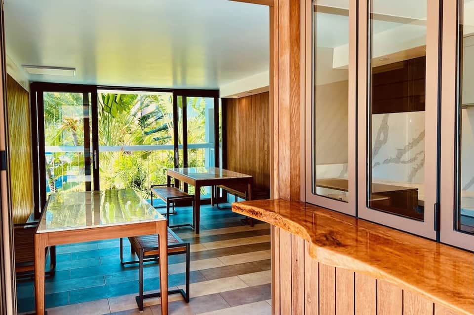 Modern office space with wooden desk, ocean view windows, and glass partition walls
