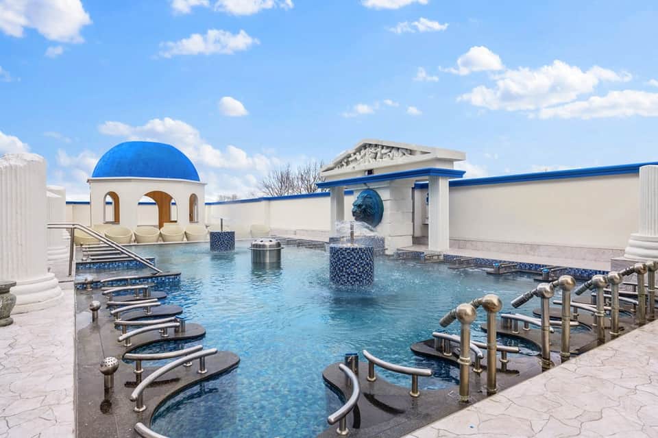 Luxurious thermal hot spring pool with Greek-style architecture and stepping areas
