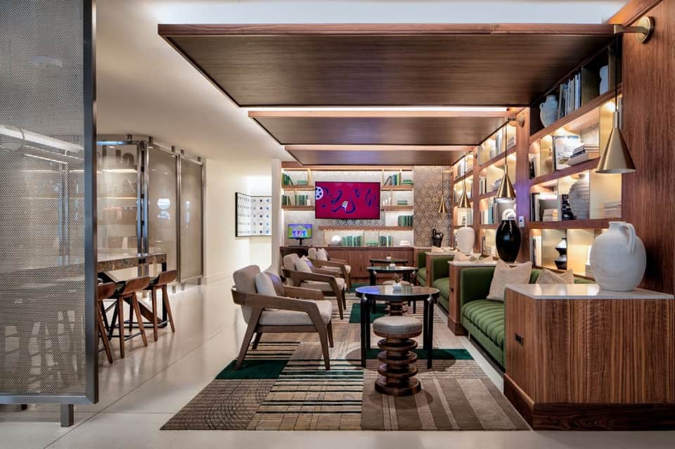 Modern lounge space with wood ceiling, custom shelving, bar seating, and contemporary furnishings throughout