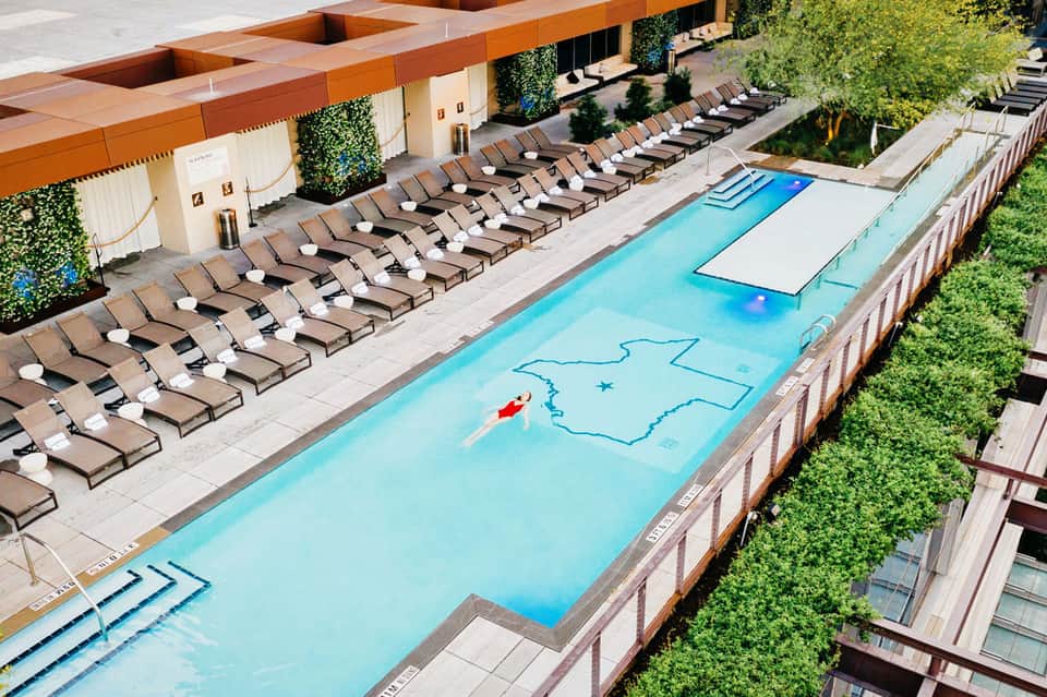 Aerial view of resort pool with lounge chairs, spa area, and manicured landscaping