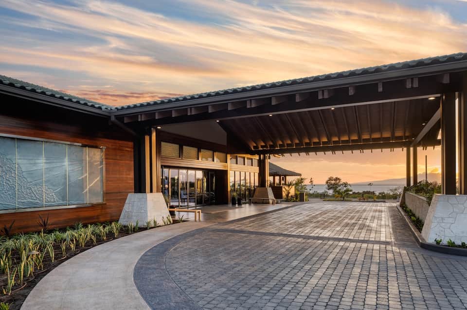 Modern architectural outdoor pavilion with wooden elements at sunset with ocean view in distance