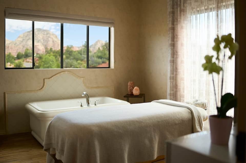Spa bathtub with mountain views through large windows and desert landscape scenery