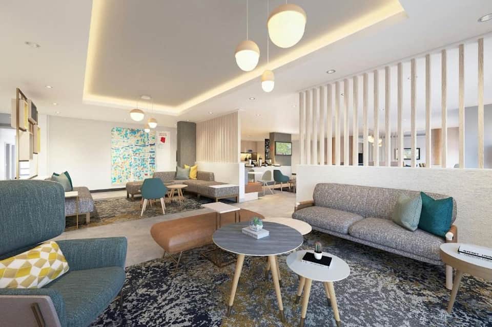 Modern hotel lobby with contemporary furniture, pendant lighting, and open layout