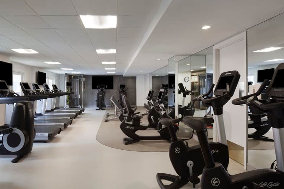 Modern fitness center with cardio equipment, exercise bikes, and mirrored walls