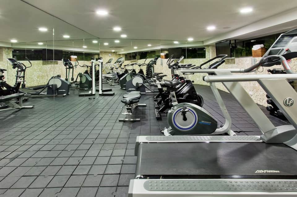 Full-service gym with cardio equipment including stationary bikes and treadmills
