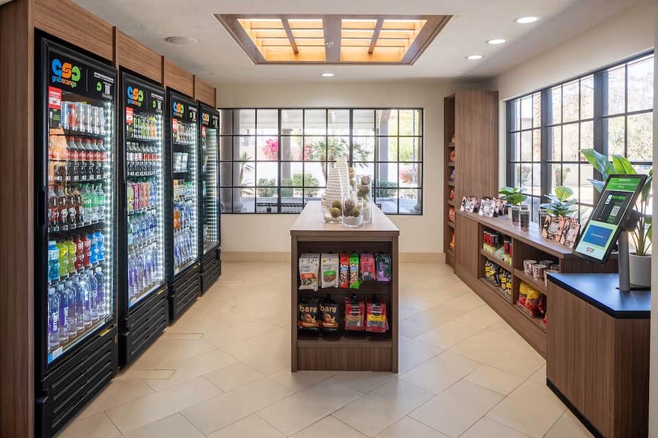 Bright convenience store interior with refrigerated beverage cases and product displays