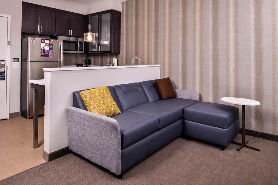 Studio apartment with kitchenette, sofa, modern furnishings, and contemporary design elements