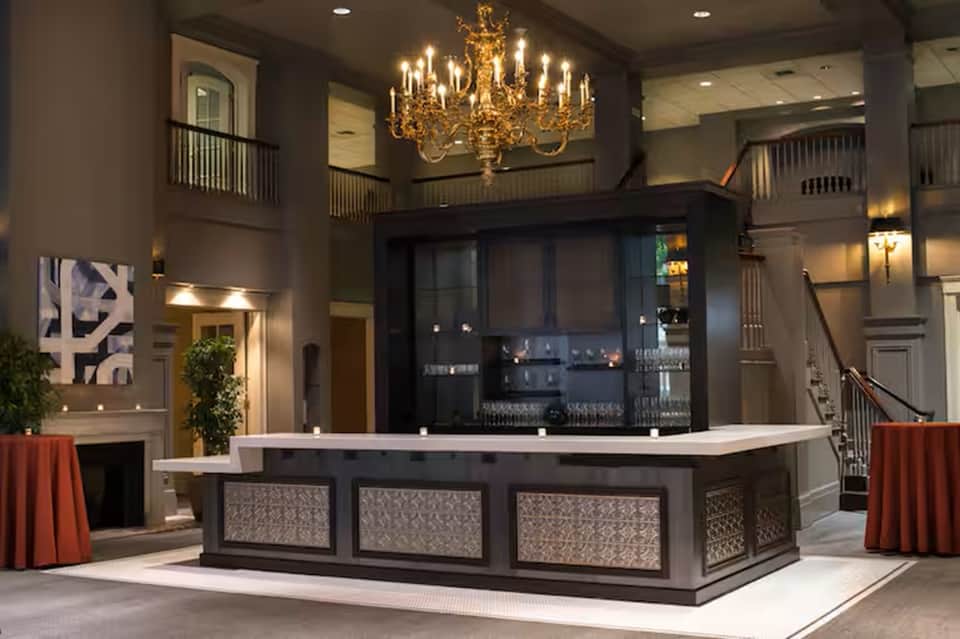 Upscale hotel lobby with grand chandelier, double-height ceilings, and elegant reception desk