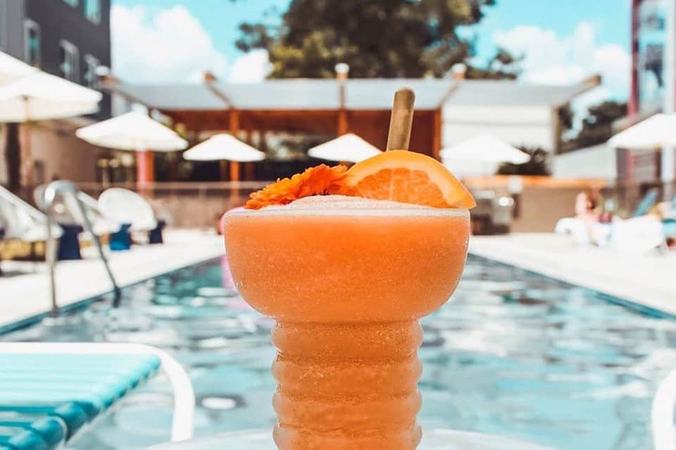Frozen orange cocktail with garnish served poolside at a resort