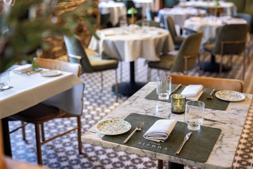 Upscale outdoor restaurant patio with marble tables and elegant place settings
