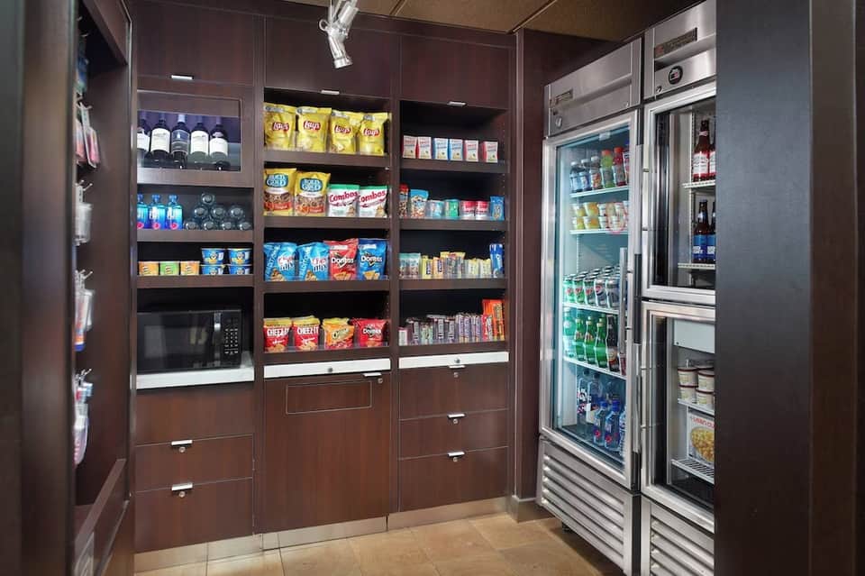 Hotel convenience store with refrigerated beverage cases and stocked shelves of snacks and beverages