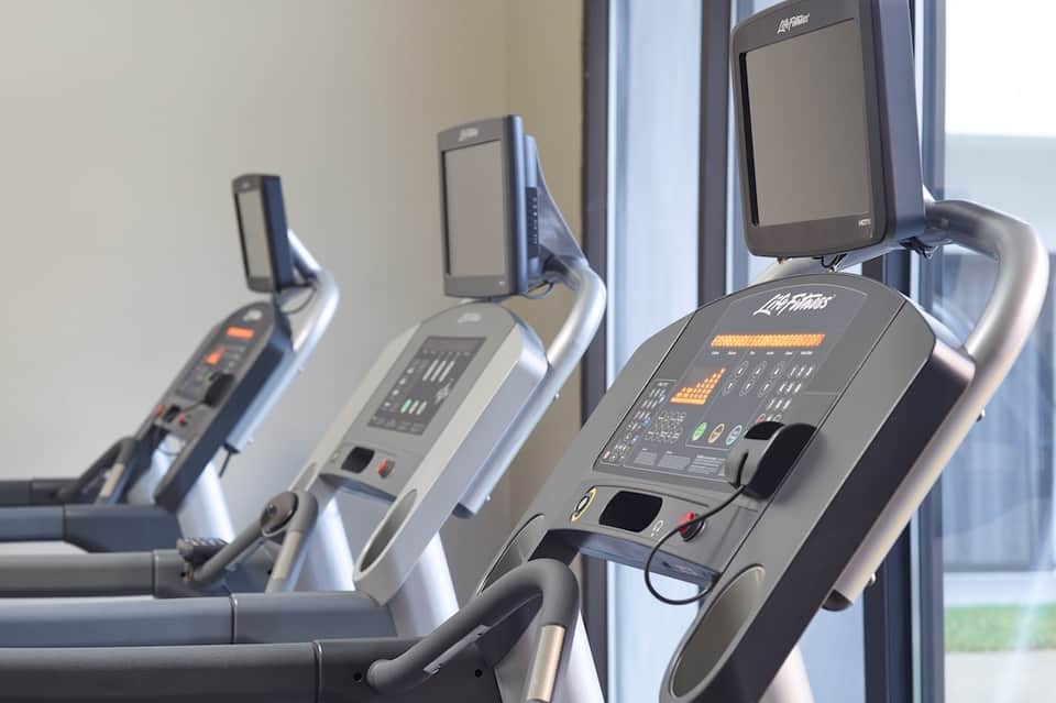 Gym fitness center with three exercise bikes and large windows overlooking landscape