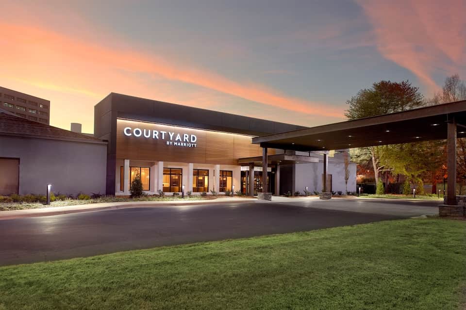 Courtyard by Marriott exterior at dusk with modern architecture and illuminated entrance.