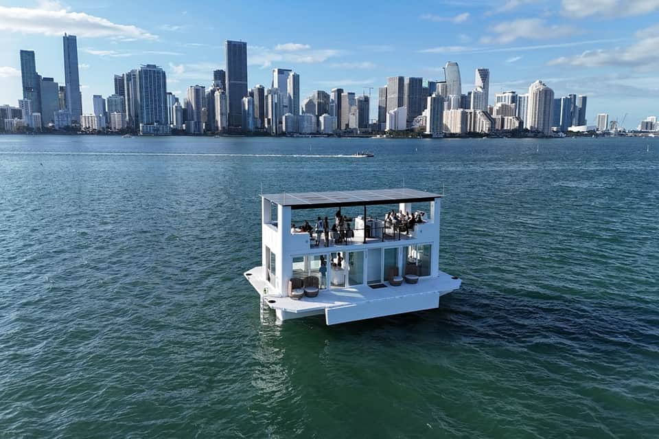 Modern white floating bar platform in turquoise water with Chicago skyline visible in background
