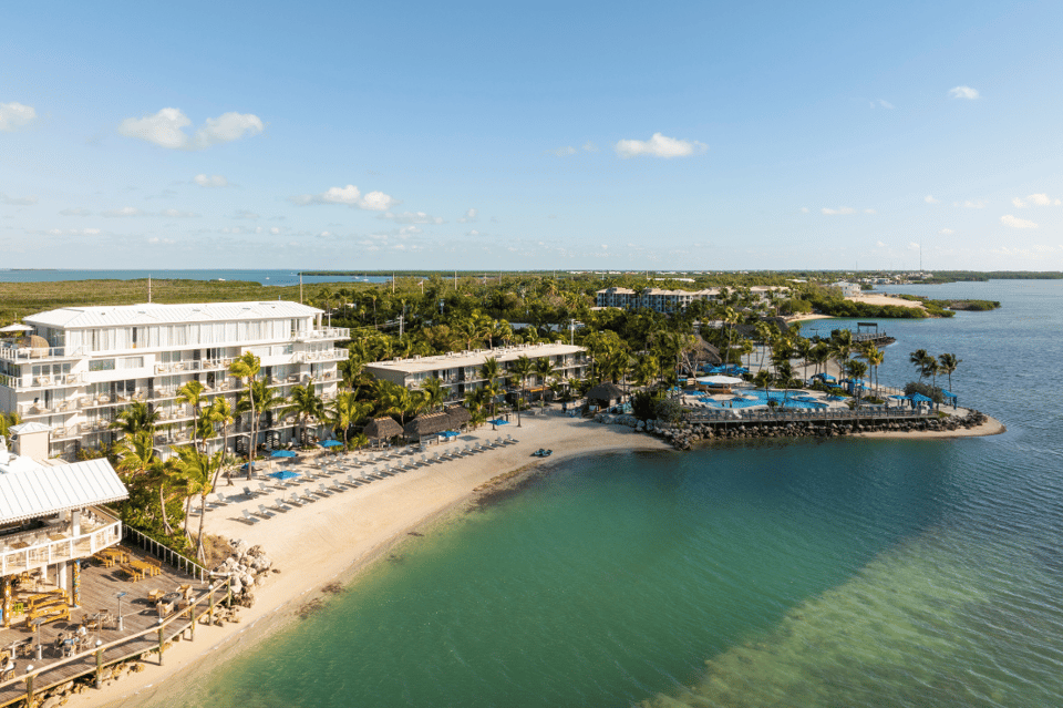 Beachfront resort with modern architecture, sandy beach, and turquoise water