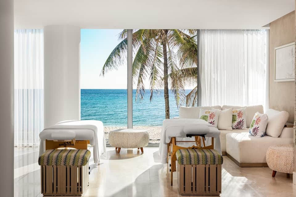 Beachfront living room with ocean view through floor-to-ceiling windows