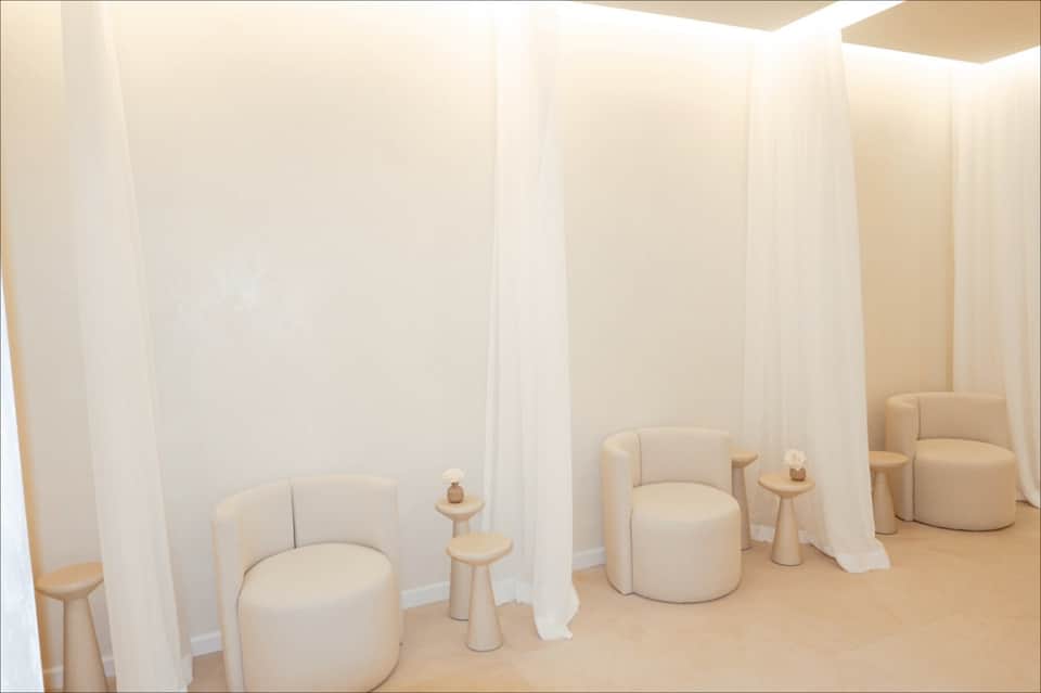 Spa relaxation area with cream-colored curved seating pods separated by curtains