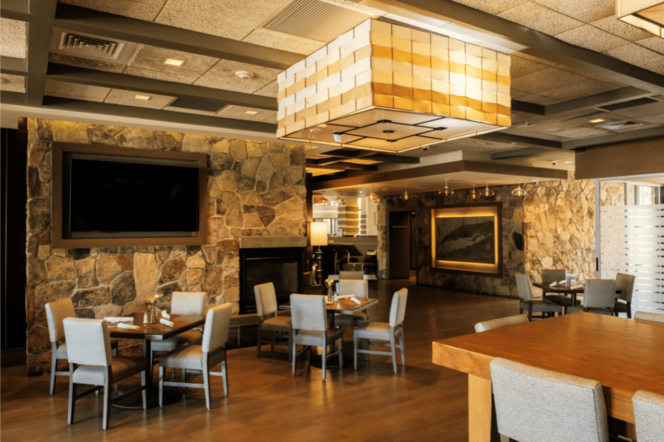 Resort dining area with stone walls, fireplace, and modern furnishings