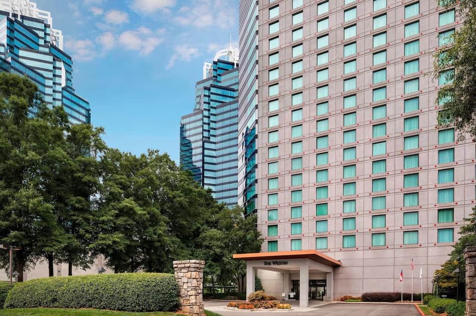 The Westin hotel exterior showing pink brick tower with teal-framed windows and landscaped grounds