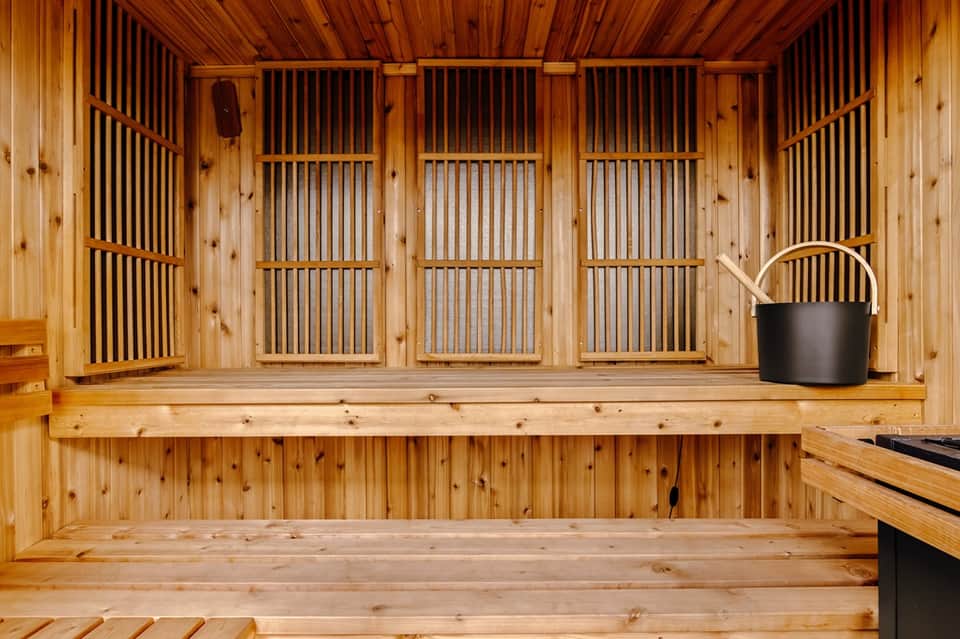 Traditional wooden sauna interior with bench seating and metal bucket