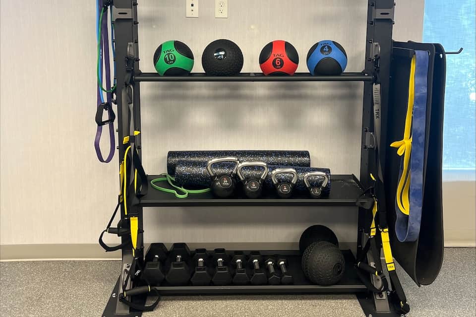 Fitness equipment storage rack with medicine balls, kettlebells, resistance bands, and foam roller