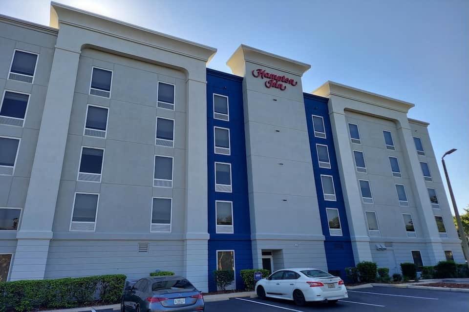 Hampton Inn hotel exterior featuring white and blue facade with signage