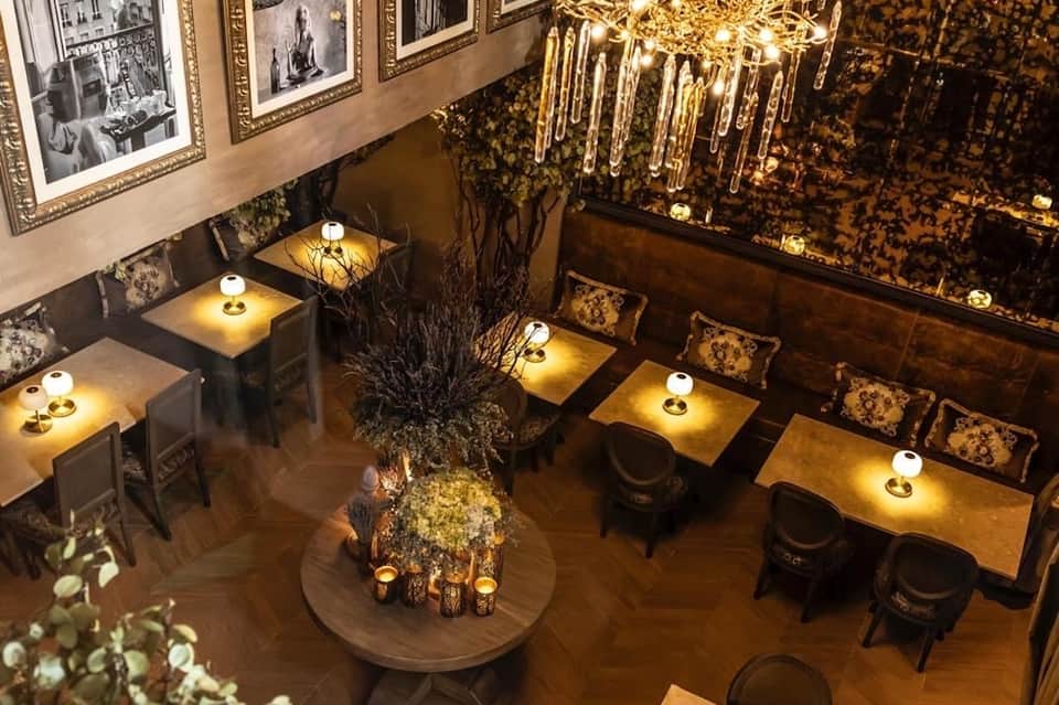 Upscale restaurant interior with ambient lighting, framed artwork, and elegant table settings