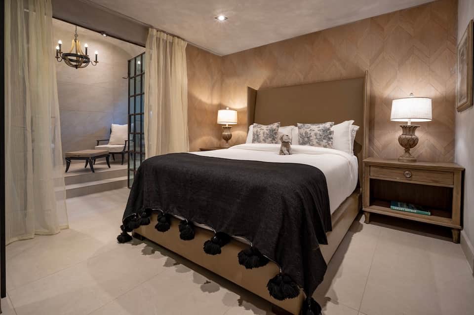 Luxury bedroom with herringbone wood walls, upholstered headboard, and ambient lighting