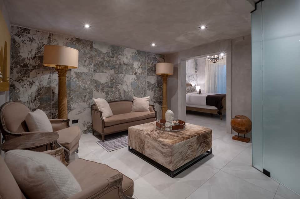 Luxury spa lounge with marble walls, cream-colored furniture, and ambient lighting