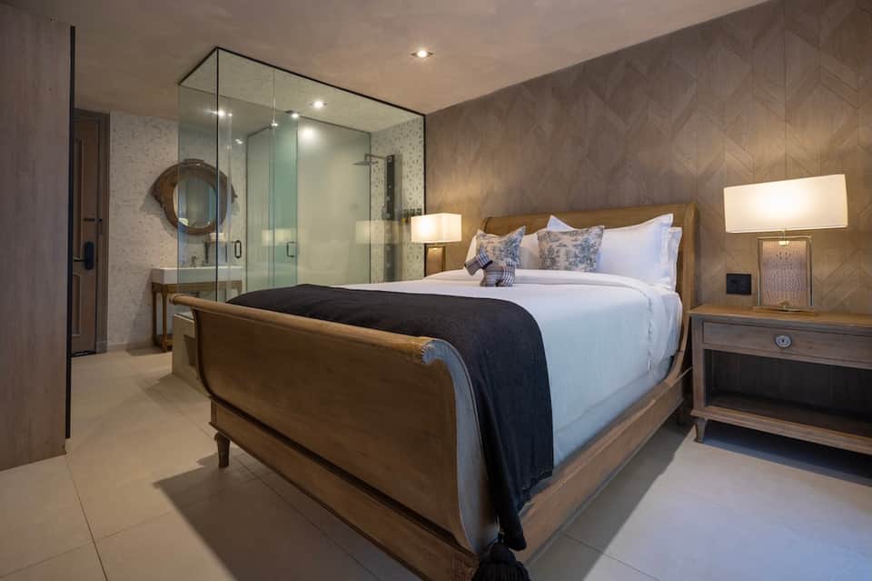 Luxury master bedroom with ensuite bathroom featuring spa shower and wooden platform bed
