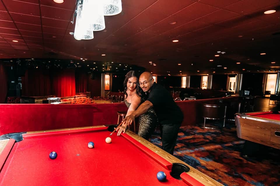 Entertainment room with red pool tables, theatrical red ceiling, and bar seating in luxury resort