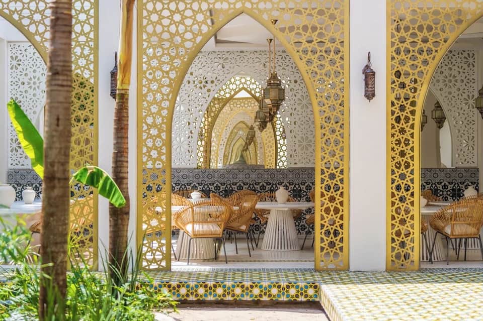 Ornate gold and white Moroccan-style dining pavilion with geometric arches and patterned tilework